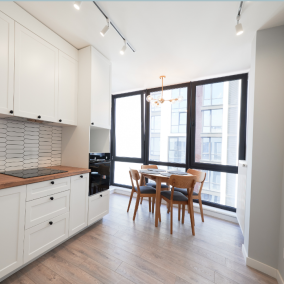 after Modern kitchen and dining area with white cabinets and wooden flooring.